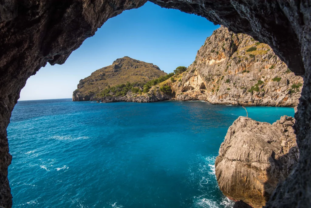 Seen from inside a cave to the blue sea and rocky cliffs bathed by the Mediterranean. Our real estate in Alicante offers housing near hidden coves and unique natural landscapes to enjoy tranquility and beauty.